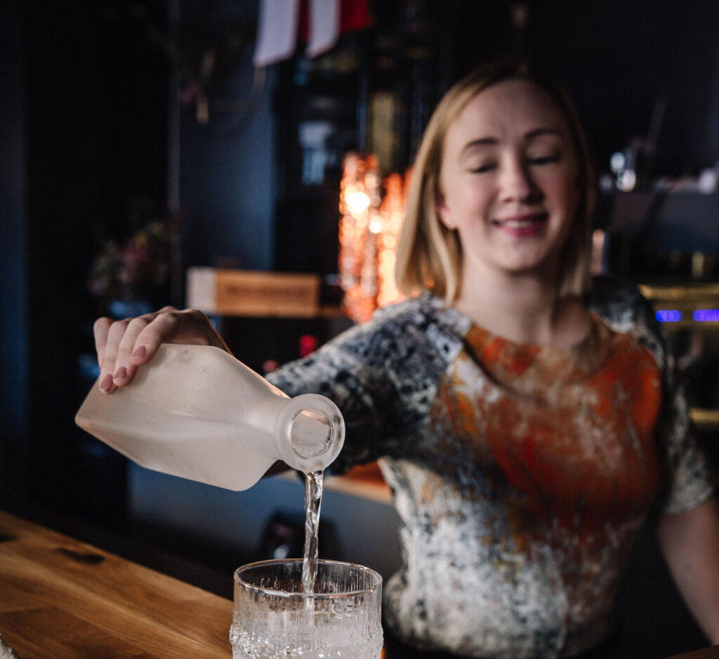 Ostoferia ravintoloitsija Jenny Kurkela kaataa vettä lasiin