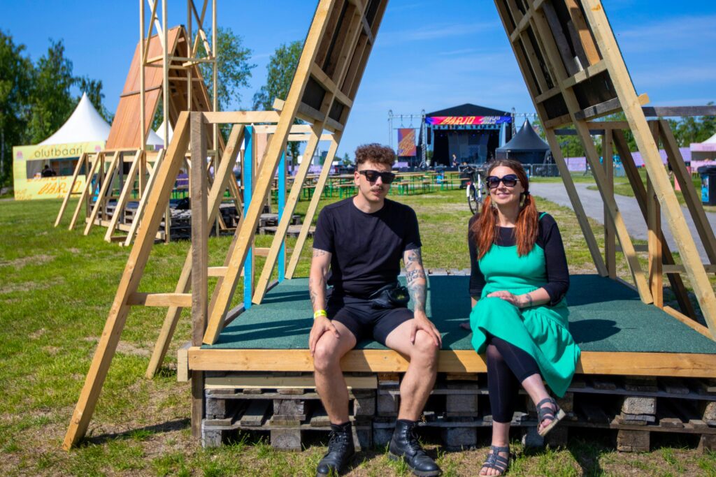 Valentino Tignanelli ja Taina Ronkainen istuvat Tignanellin toteuttaman paviljongin reunalla Varjo-festivaalilla kesällä 2023.
