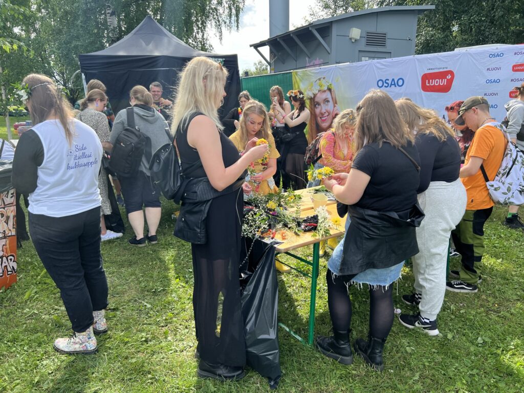 Kesäfestivaalilla tehdään kukkaseppeleitä festarivieraille.