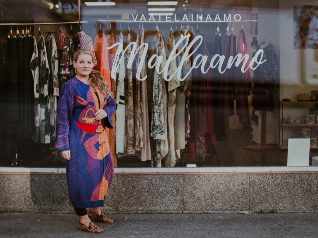 Vaatelainaamo Mallaamo - nainen liikkeen edessä
