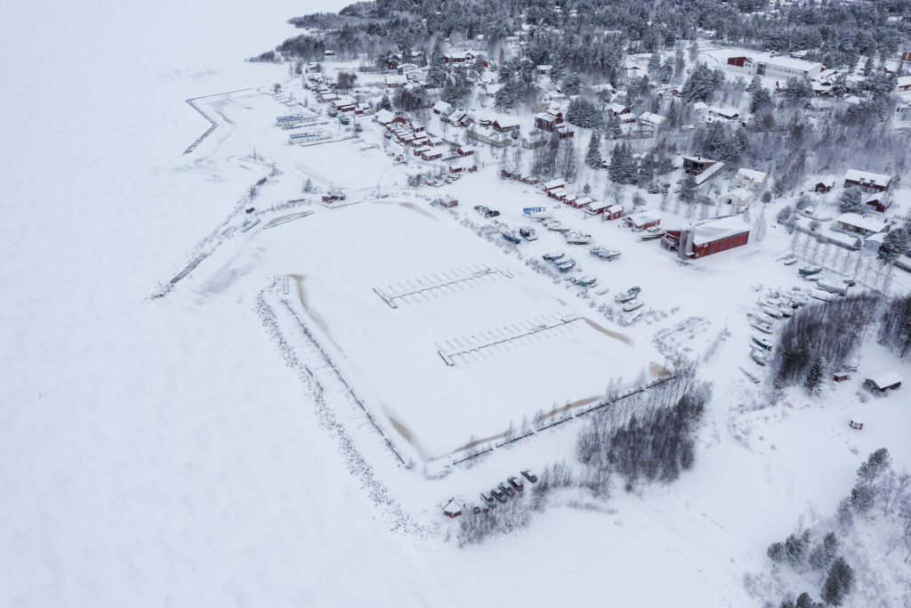 Snow-covered village and frozen harbour aerial view
