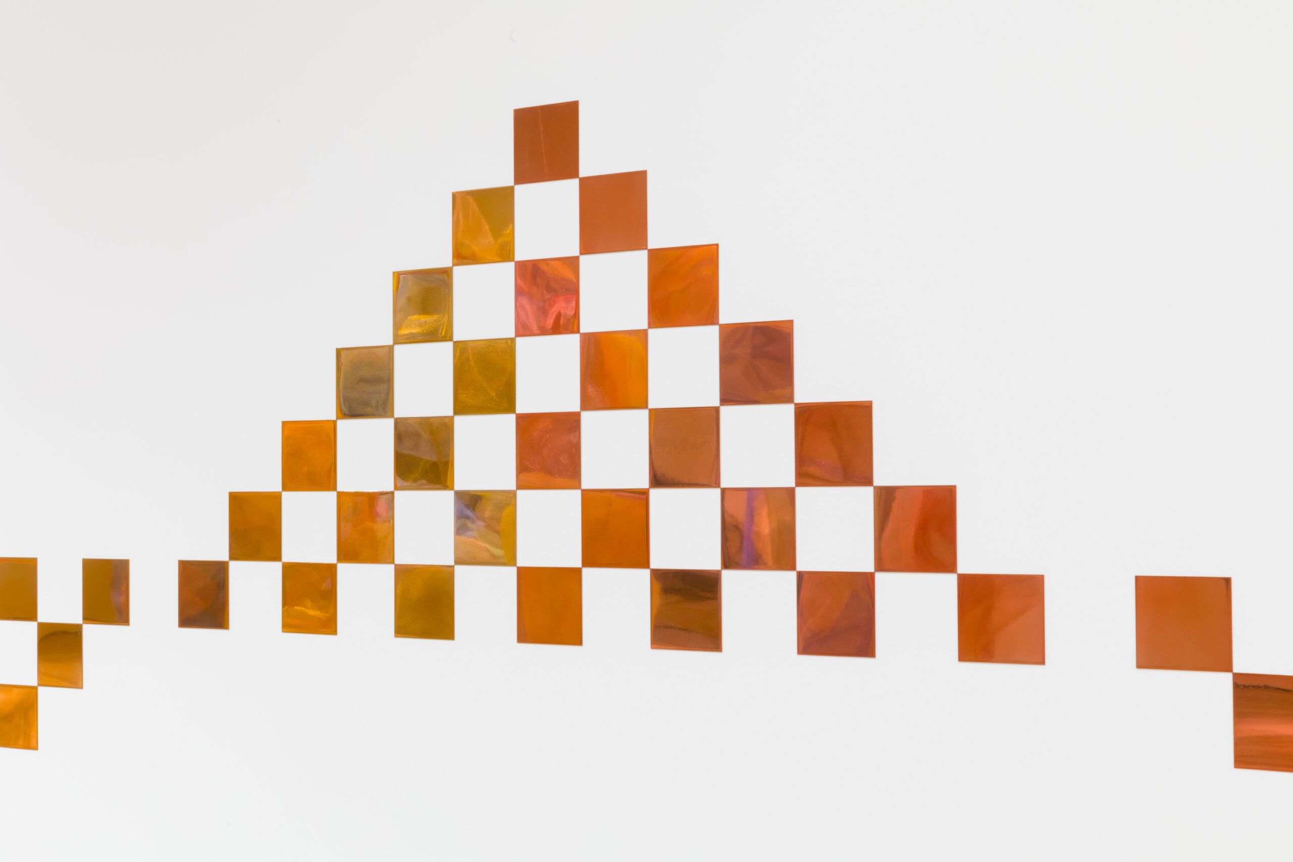 Abstract orange and white checkered pattern on wall.