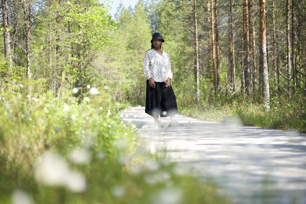 Person walks on a sunny forest path.