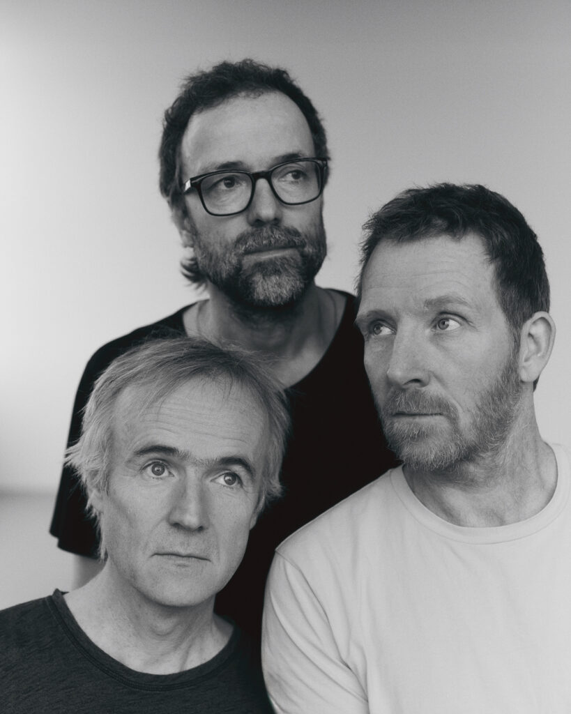 Three men looking in different directions.