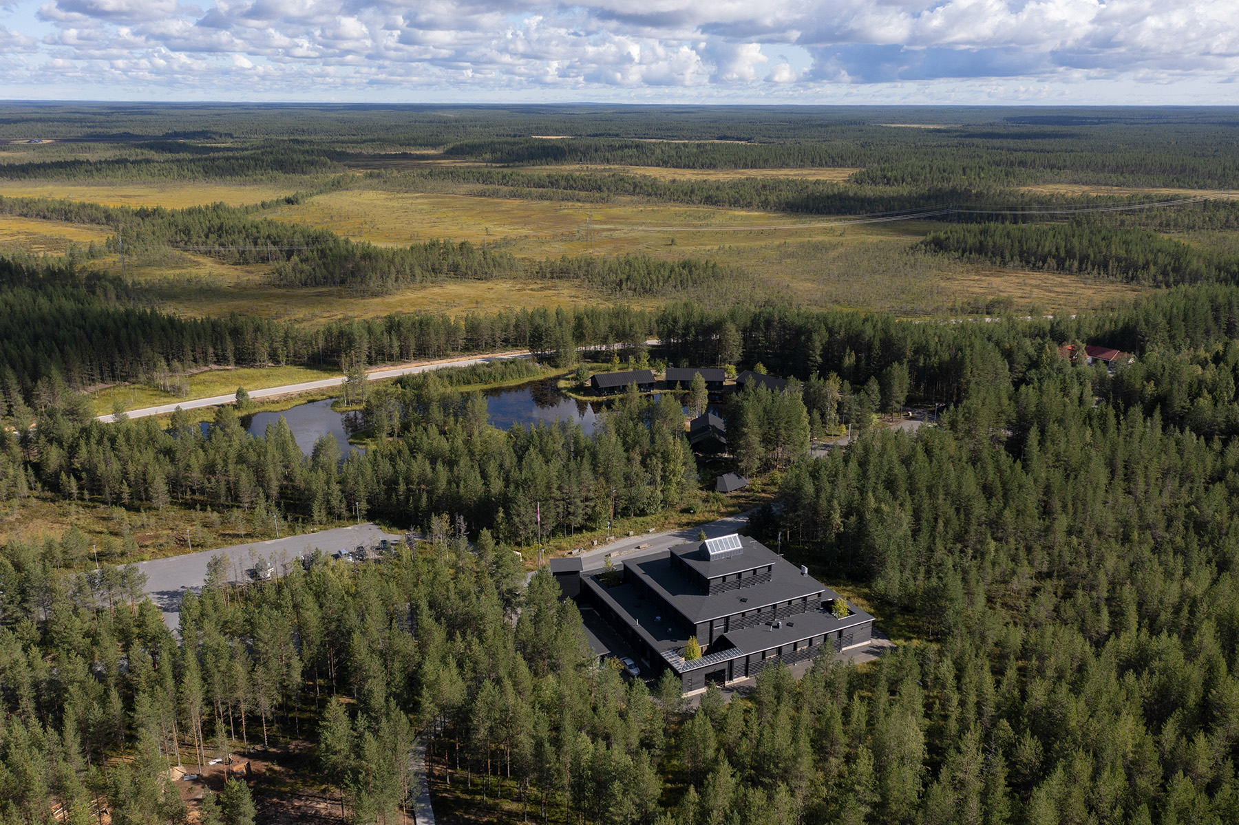 Aerial view of modern building in forest landscape.